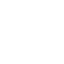 A group of people in a cooking class standing around a big island table learning to cook.