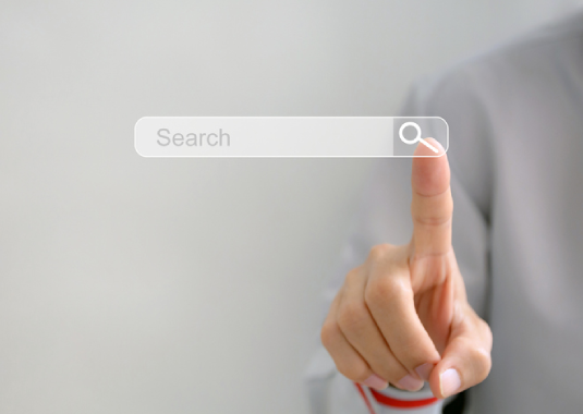 Close-up of a hand reaching to touch a search engine on a digital screen, symbolizing online searching, browsing, and digital interaction.